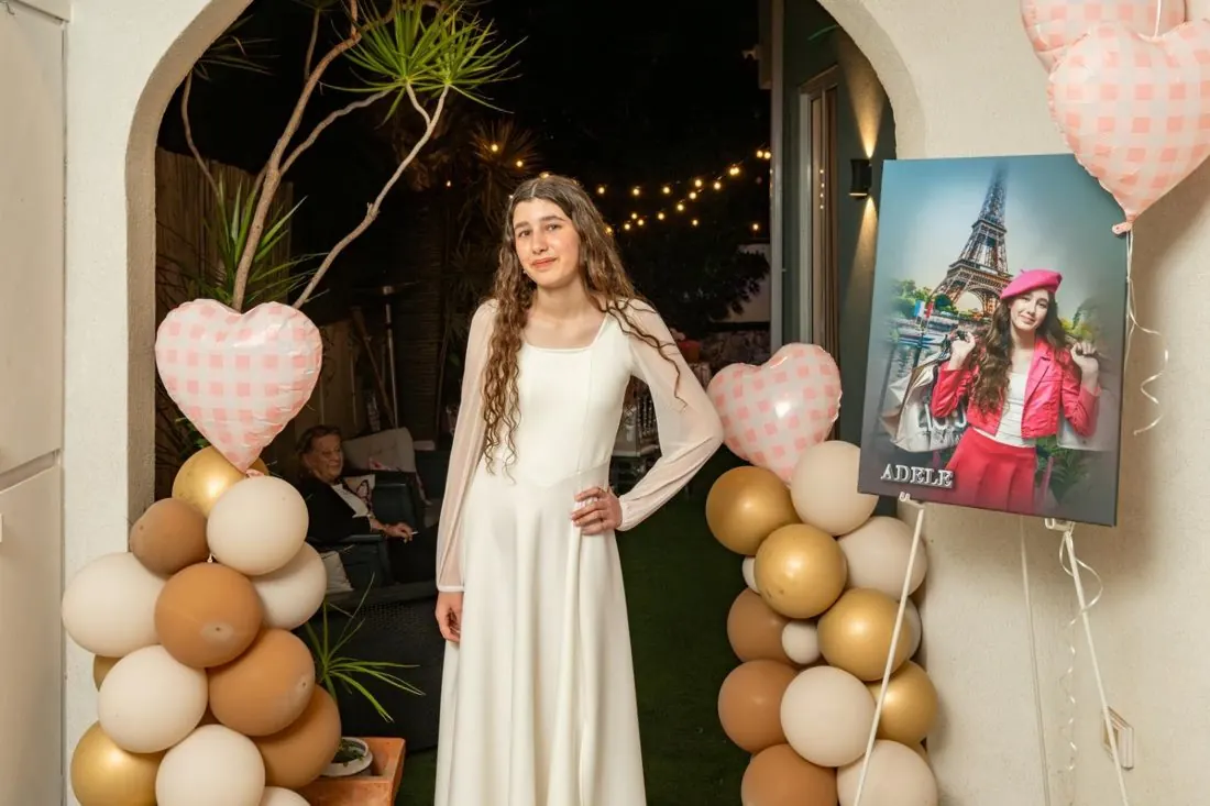 בת המצווה בשמלה לבנה בכניסה לחגיגה